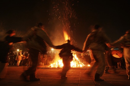 Bulgarians carry bells on their waists as they dance around a bonfire during their "Kukeri" ritual in the town of Batanovtsi, some 35 km ( 22 miles) south from the capital Sofia, on late Monday, Jan. 13, 2014. "Kukeri" is a pagan Bulgarian masked ritual of Thracian origins, performed between Christmas and Lent by costumed men in sheepskin garments, bells and masks, who walk around and dance to scare away the evil spirits, in hope to provide a good harvest, health, fertility, and happiness. (AP Photo/Valentina Petrova) ORG XMIT: VP107